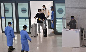 Médicos guían a viajeros provenientes de China en el aeropuerto de Corea del Sur