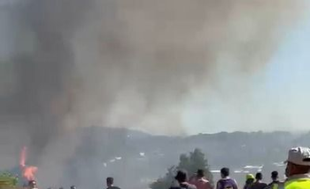 Captura de pantalla del video donde se ven algunas llamas del incendio en Pueblo Obrero y vecinos luchando para extinguirlas