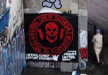 Una mujer pasa junto a un mural que representa el logotipo del grupo mercenario Wagner en Belgrado