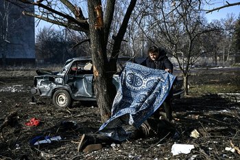Una persona fallecida es tapada en una calle de Ucrania, el primer día de ofensiva rusa