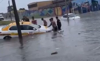 Taxi bajo agua intenta ser salvado por los vecinos