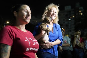 La intendenta de Montevideo junto a uno de los perros en adopción durante el partido entre Defensor y Fénix