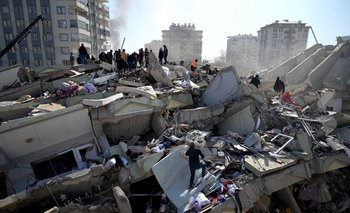 Las familias de las víctimas se paran mientras los equipos de rescate buscan entre los escombros de los edificios derrumbados en Kahramanmaras, el 9 de febrero de 2023, tres días después de que un terremoto de magnitud 7,8 azotara el sureste de Turquía.