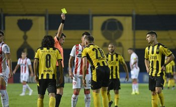 Andrés Cunha le muestra la tarjeta amarilla a Giovanni González ante River y el futbolista queda automáticamente suspendido para jugar ante Montevideo City Torque
