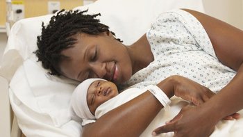 Una mujer carga a su bebé recién nacido