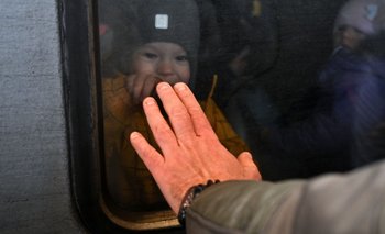 Un bebe se despide de su padre desde adentro de un tren