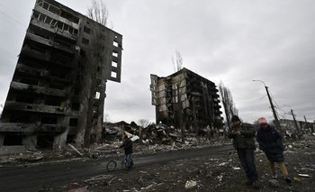 Los residentes locales pasan por un edificio destruido en la ciudad de Borodianka, al noroeste de Kiev, este miércoles