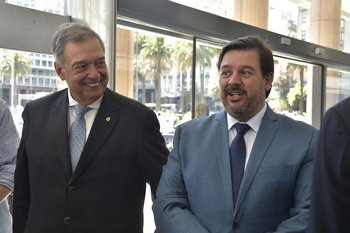 Los ministros Fernando Mattos y Adrián Peña al entregarle su planteo al presidente.