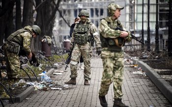 Soldados rusos caminan por las calles de Mariúpol, ciudad asediada hace semanas por las fuerzas rusas