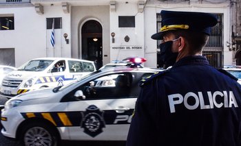 Efectivo policial y patrulleros frente a la fachada del Ministerio del Interior, en Montevideo