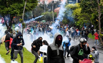 Manifestantes chocan con la policía antidisturbios durante una protesta contra un proyecto de reforma tributaria frente a la casa del presidente colombiano
