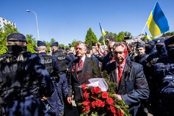 El embajador Andréyev (izquierda) se retira del cementerio de soldados rusos de Varsovia tras recibir el ataque con pintura roja