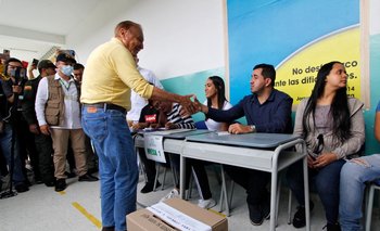 El candidato presidencial independiente colombiano Rodolfo Hernández le da la mano a un hombre que preside el colegio electoral en Bucaramanga, Colombia