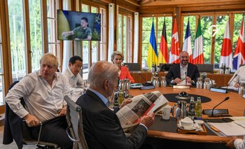 Joe Biden lee el diario en una mesa redonda, acompañado de otros líderes del G7