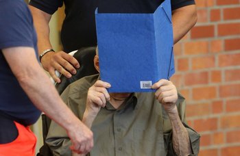 Josef Schuetz de 101 años se tapa la cara a lo que llega a declarar este martes 28 de junio de 2022