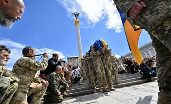 Archivo, 22 de junio: Soldados ucranianos se arrodillan mientras otros camaradas cargan el cajón del fallecido comandante Oleh Kutsyn
