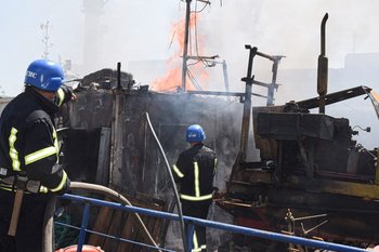 Los bomberos ucranianos luchando contra un incendio en un barco que ardía en el puerto de Odessa después de que los misiles impactaran en el puerto el 23 de julio de 2022.