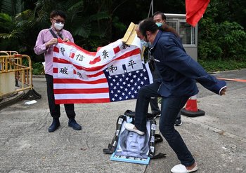 Un protestante pro-Beijing aplasta con su pie una imagen de Nancy Pelosi; afuera del consulado estadounidense en Hong Kong