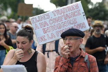 Un hombre sostiene un cartel que dice "Electos, traidores de mi confianza. Indigno del cargo" durante una manifestación contra el pase de salud obligatorio Covid-19 para acceder a la mayor parte del espacio público, en Nantes.