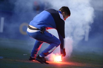 En el último clásico los hinchas de Peñarol lanzaron dos bengalas a la tribuna de Nacional, una cayó en la cancha y es retirada por un funcionario