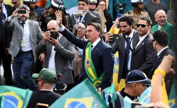 El presidente de Brasil, Jair Bolsonaro, saluda al público durante el desfile militar