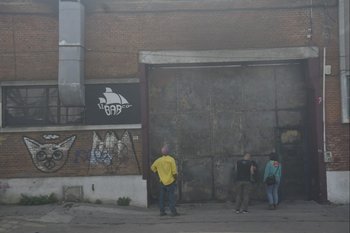 Vecinos y artistas miran por un hueco lo que quedó del bar El Barco