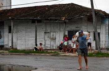 Un hombre carga una bolsa de comida en Cuba para abastecerse ante la llegada del huracán Ian a la isla