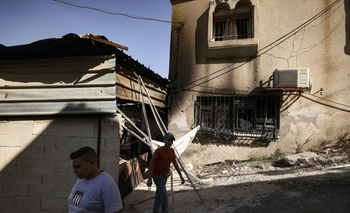 Ciudadanos palestinos inspeccionan un hogar que fue golpeado por un misil