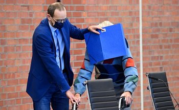 El anciano, acusado de crímenes nazi, escondió su rostro de la prensa con ayuda de una carpeta azul
