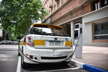 Un taxi eléctrico se carga al lado de la Intendencia de Montevideo.