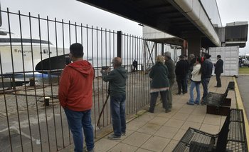 Personas esperan la salida de pasajeros de un barco en el Puerto de Montevideo. (Archivo)