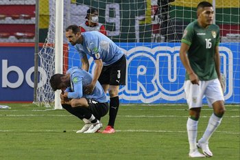 Diego Godín intenta levantar a Rodrigo Bentancur al finalizar el partido contra Bolivia
