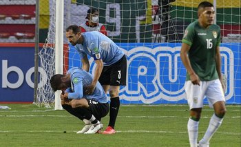 Diego Godín intenta levantar a Rodrigo Bentancur al finalizar el partido contra Bolivia