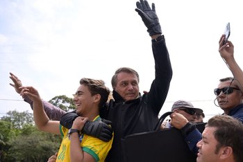 Jair Bolsonaro (derecha) y Nikolas Ferreira (izquierda) saludan a sus seguidores en Poços de Caldas