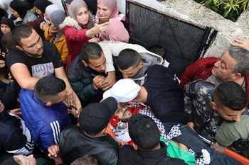 Personas en duelo alrededor de uno de los cuerpos de palestinos asesinados durante los encuentros con las fuerzas armadas de Israel en su pueblo natal de Beit Rima en la ocupada Cisjordania, el 29 de noviembre de 2022