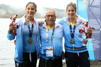 Yuliana Etchevarne, Zoe Acosta y el entrenador Osvaldo Borchi con la medalla de oro