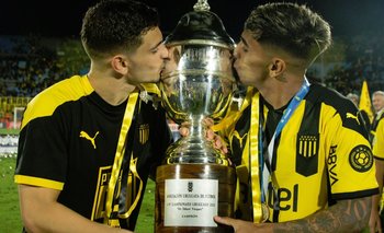 Agustín Álvarez Martínez y Facundo Torres besan la Copa Uruguaya que ganaron con Peñarol por primera vez