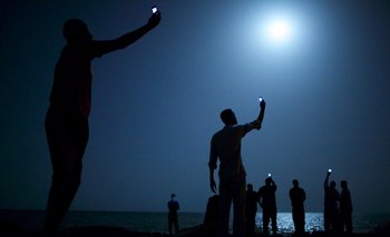Migrantes africanos en la costa de Yibuti, buscando señal en sus celulares. Elegida mejor foto del año