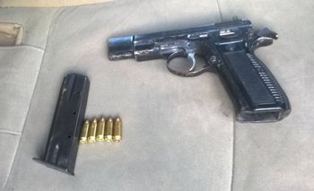 La Policía incautó este domingo esta pistola, con el cargador y cinco balas entre las banderas de Peñarol<br>