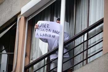 Un vecino saca un cartel en apoyo a Uber en medio de las protestas de los taxistas