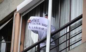 Un vecino saca un cartel en apoyo a Uber en medio de las protestas de los taxistas
