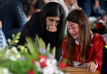 Familiares lloran sobre el ataúd de una persona que murió a raíz del terremoto en Amatrice, Italia