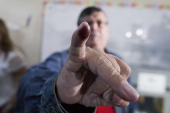Un elector muestra su dedo con tinta luego de haber votado en Honduras