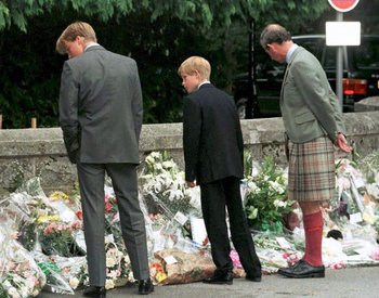 Los príncipes Guillermo y Enrique junto a su padre, el príncipe Carlos, observando los tributos florales en honor a la muerte de Diana en 1997